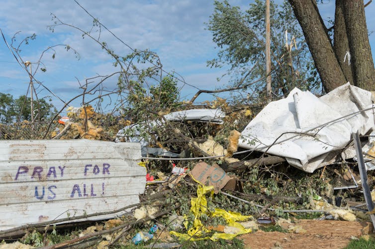 Debris with 'pray for us all' sign