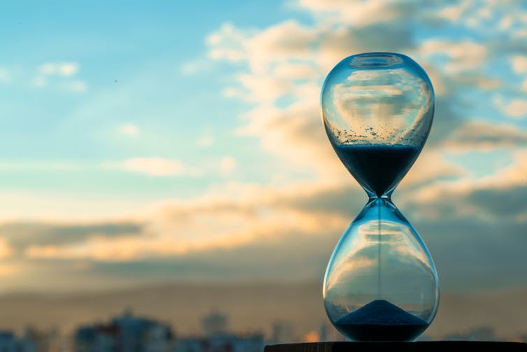 hourglass, sand timer, blue sky in background