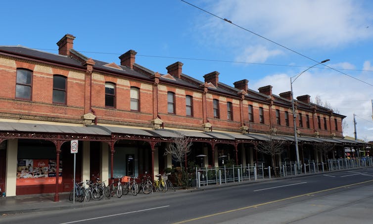 A row of Victorian shops with canopies creating shade in Melbourne, Australia.