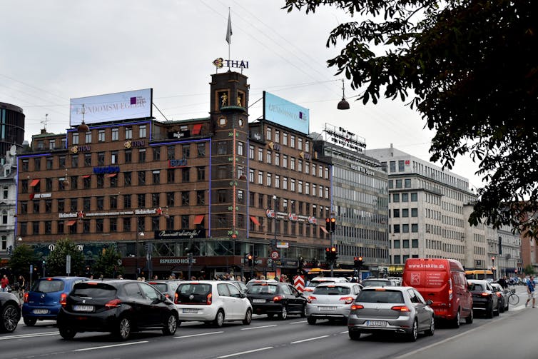 A large thermometer mounted on the side of a building in busy street in Copenhangen, Denmark.