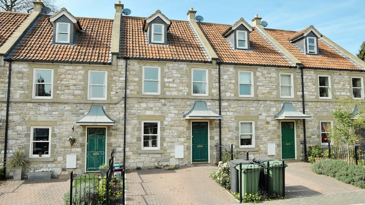 A terrace of houses with paved driverways.